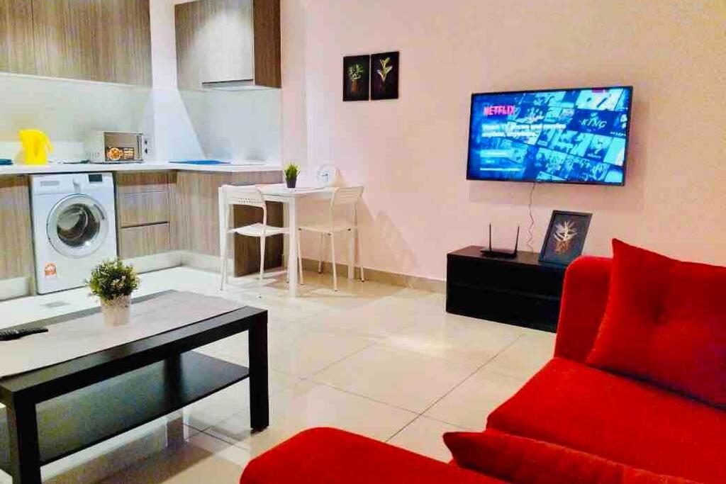 塞贝维HB1512- Hyve Studio unit, Lake view, Cyberjaya, Free Wi-Fi, Free Parking, Netflix,Pool, 3038的一间带红色沙发的客厅和一间厨房