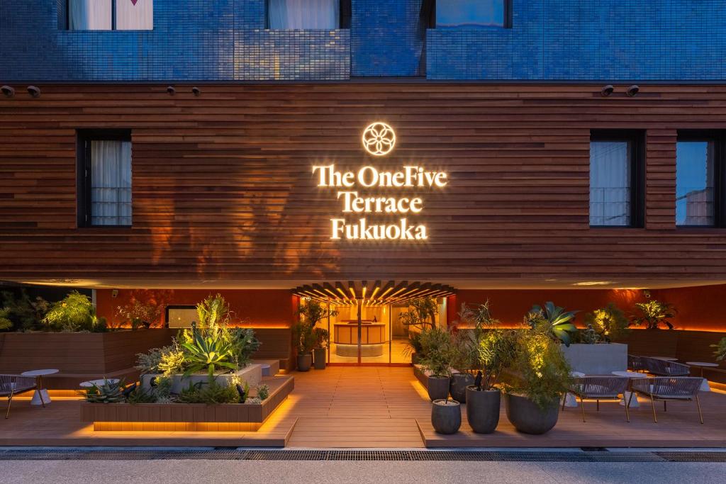 福冈The OneFive Terrace Fukuoka的一座建筑,上面有标志,上面有书写着外面的露台法尔科费城的标志
