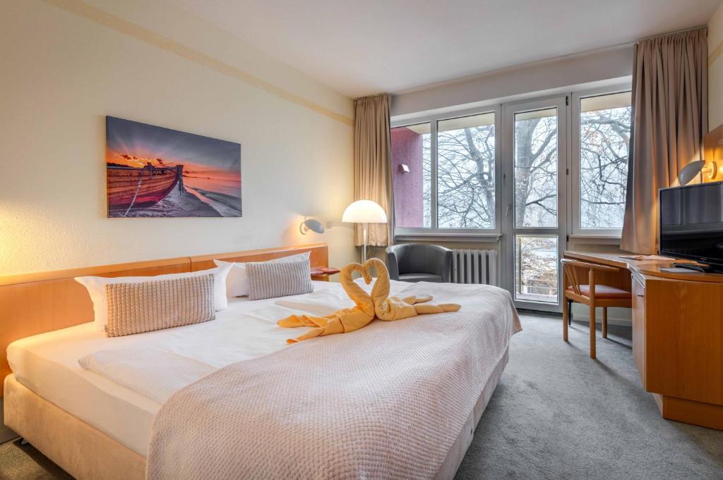 黑灵斯多夫沃尔德酒店的一间酒店客房,配有一张带毛巾的床