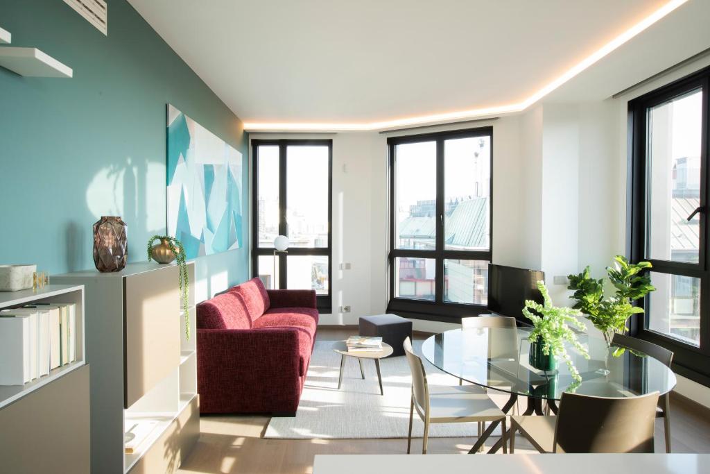 米兰Milan Eleven by Brera Apartments的客厅配有红色的沙发和桌子