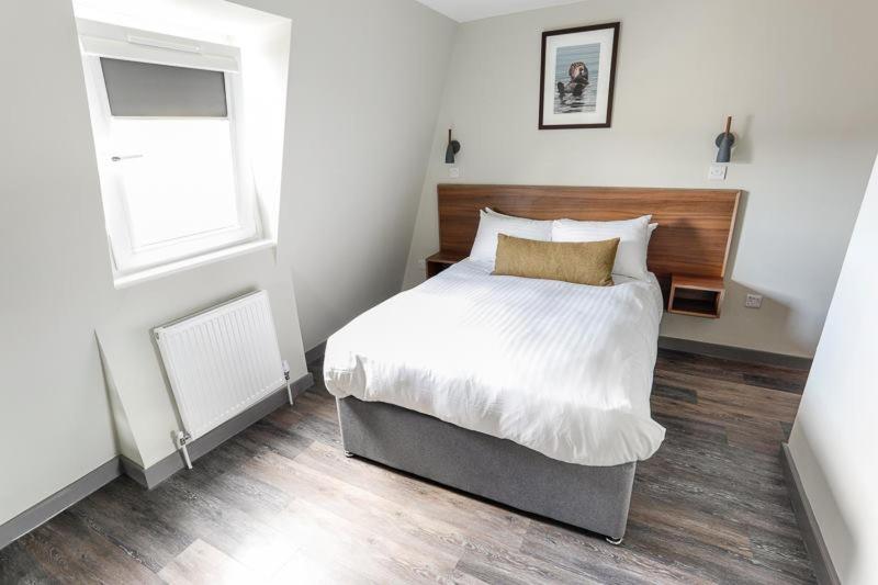 柯金蒂洛赫Broadcroft Hotel的一间卧室设有一张大床和一个窗户。