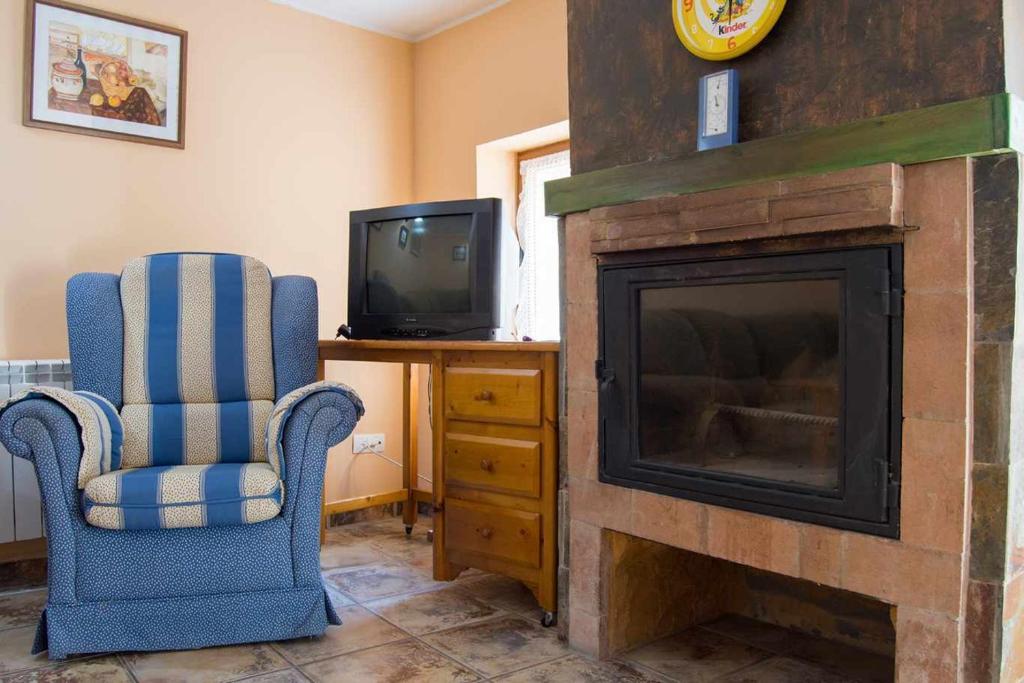 La ParrillaCasa rural con jacuzzi的客厅设有壁炉和电视。