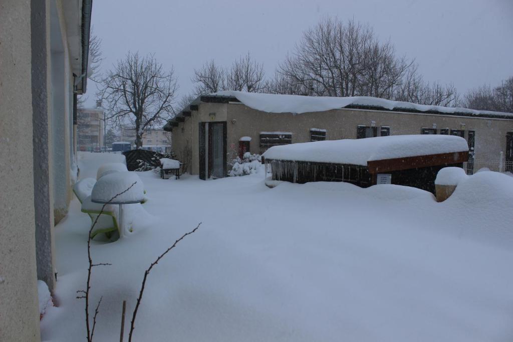 尚普索地区圣博内康内塔布勒酒店的一座房子旁边的积雪堆成的院子