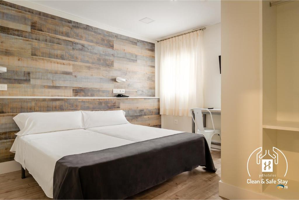 格拉纳达YIT Casablanca的一间卧室设有一张床和木墙