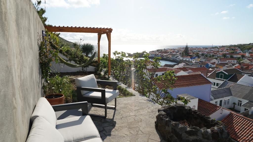 奥尔塔Casa Volta do Mar的阳台配有白色椅子,享有城市美景