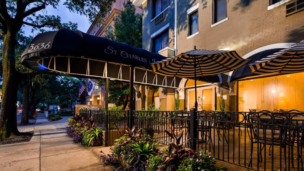 新奥尔良St Charles Inn, Superior Hotel的一间咖啡厅,配有遮阳伞和桌椅