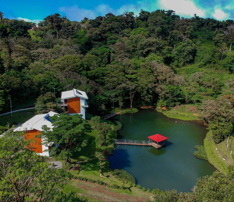 蒙泰韦尔德哥斯达黎加Burbi Lake Lodge Monteverde的享有湖泊的空中景致,设有房屋和码头