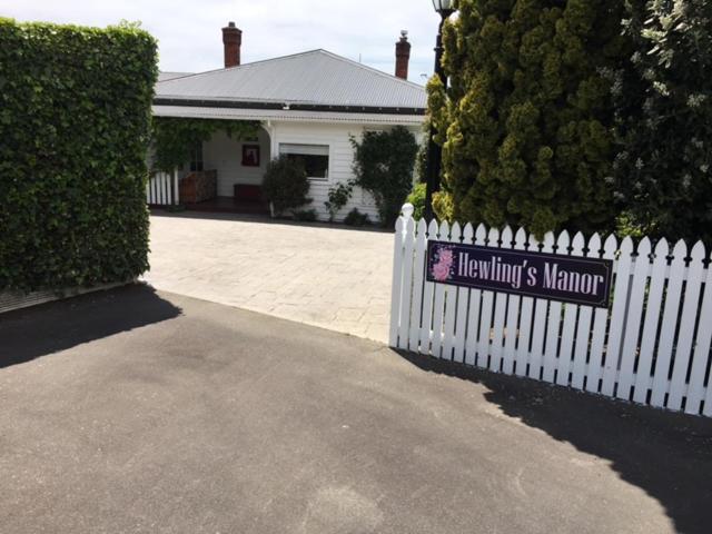 杰拉尔丁Hewling's Manor的房屋前有标志的白色围栏