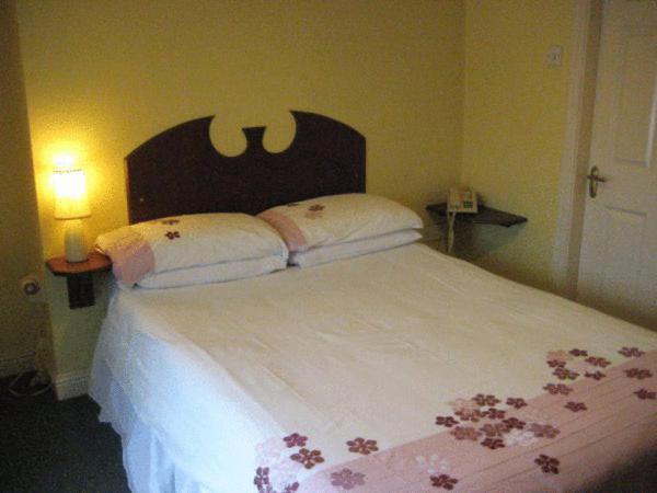 沃特福德安克雷奇酒店的一间卧室配有一张带鲜花的大床