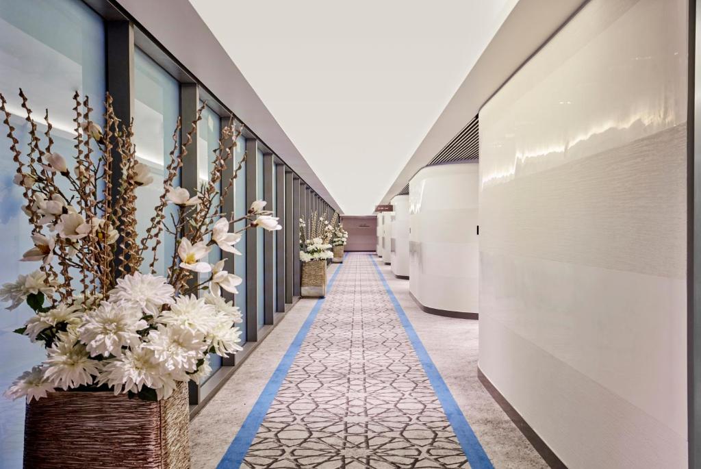 马斯喀特Aerotel Muscat - Airport Transit Hotel的建筑一侧有鲜花的走廊