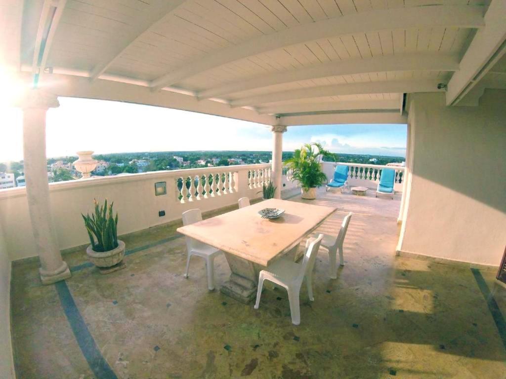 博卡奇卡One bedroom apartement with sea view jacuzzi and furnished terrace at Boca Chica的阳台的天井配有桌椅