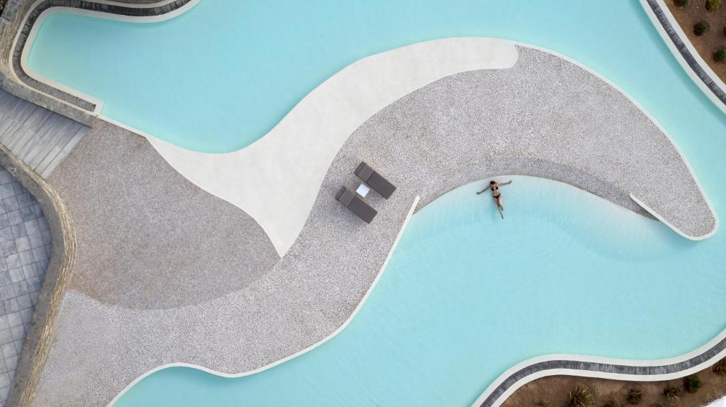 洛加拉斯Summer Senses Luxury Resort的站在波浪前的人的头顶视图