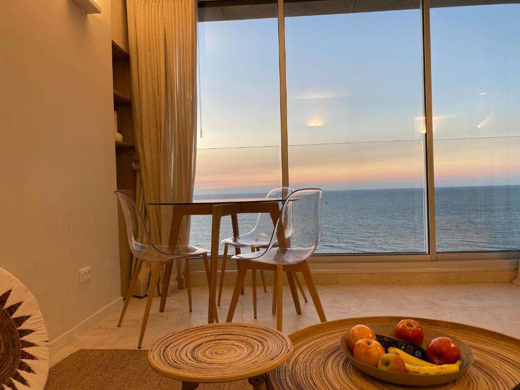 荷兹利亚daniel hotel beach view boutique apt的客厅配有桌子,享有海景
