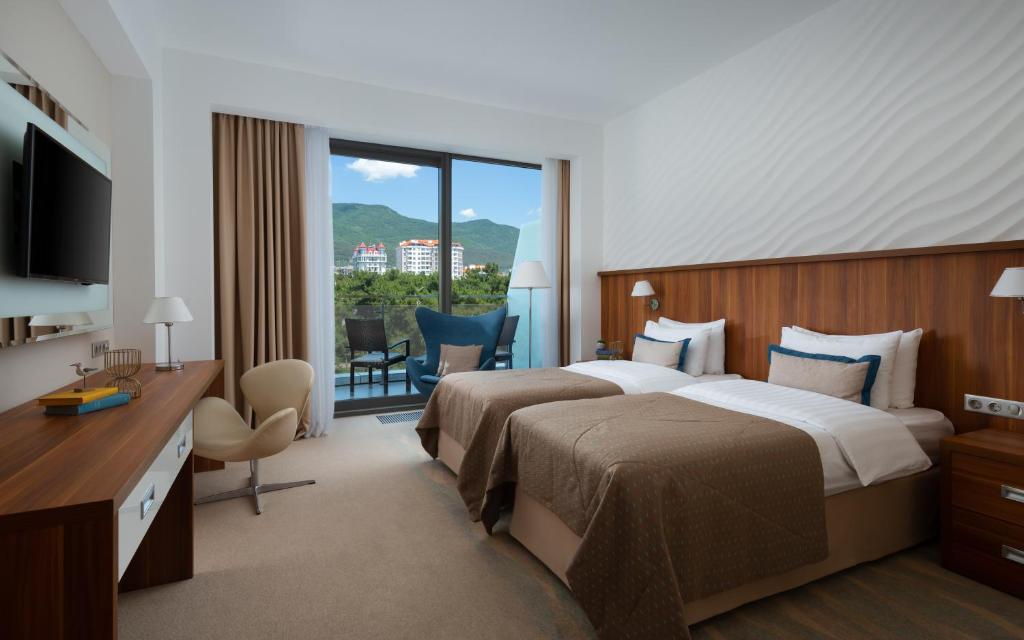 格连吉克Primorie Grand Resort Hotel 5*的酒店客房设有两张床和一个阳台。
