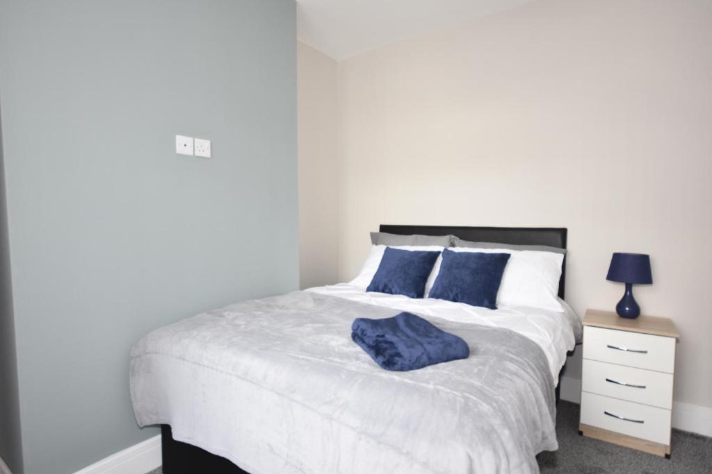 特伦特河畔斯托克Townhouse @ Penkhull New Road Stoke的一间卧室配有白色床和蓝色枕头