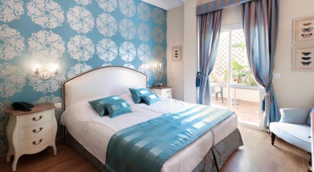 马贝拉中心精品酒店的一间卧室配有一张蓝色墙壁的床和一扇窗户