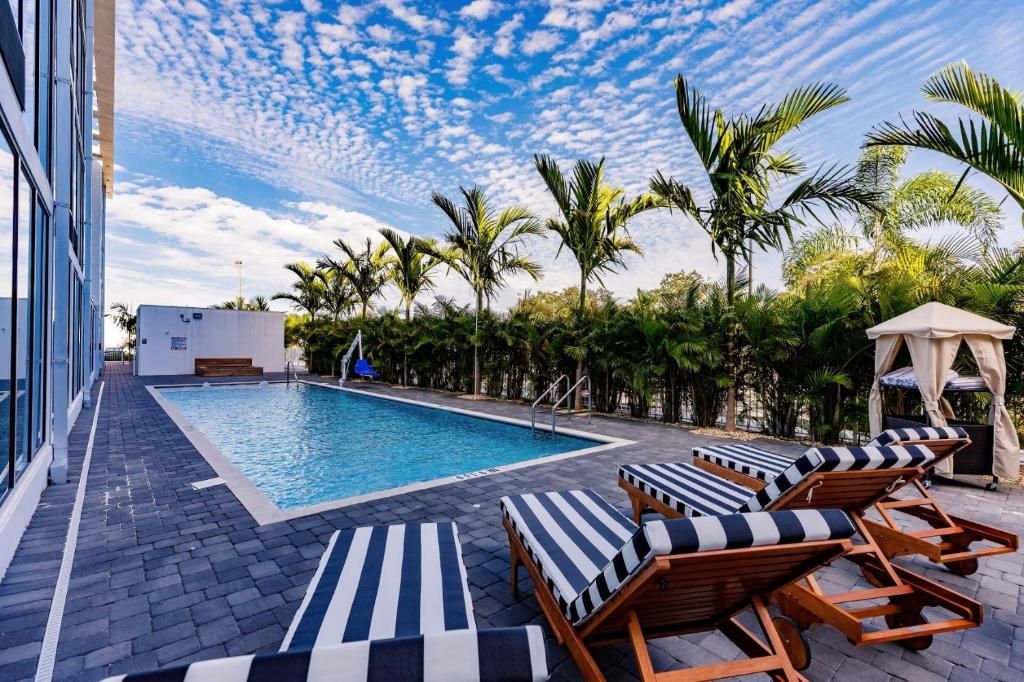 萨拉索塔Kompose Boutique Hotel Sarasota的毗邻度假酒店的带躺椅的游泳池