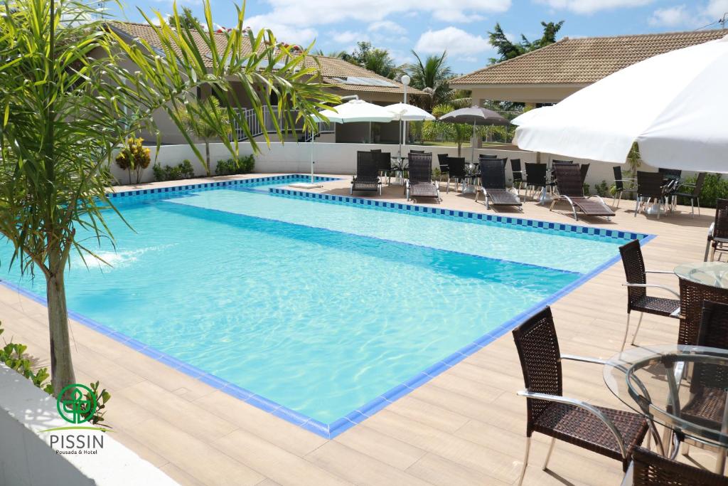 马里利亚PISSIN POUSADA E HOTEL的一个带椅子和遮阳伞的大型游泳池