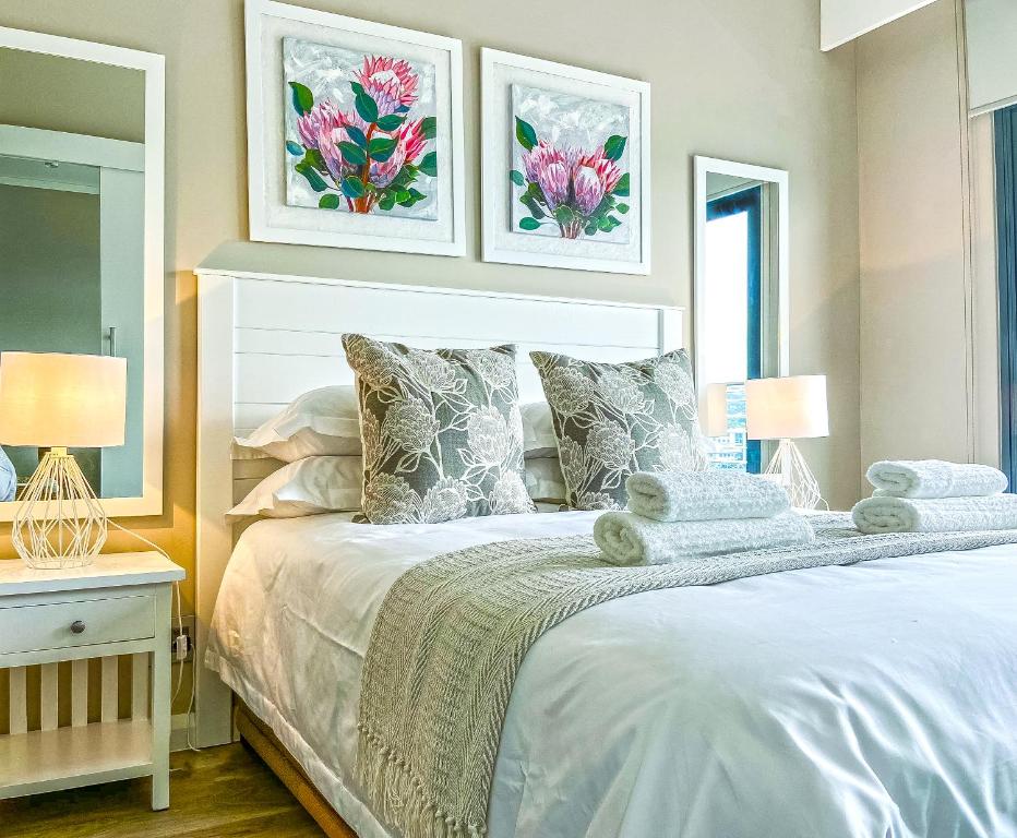 比勒陀利亚Menlyn Maine Residence Knysna的一间卧室配有一张带两盏灯的大型白色床。