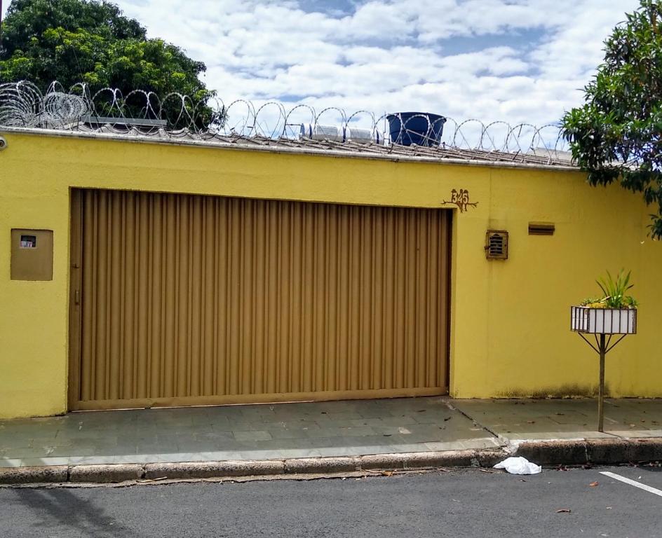 乌贝兰迪亚Casa Amarela的一条黄色的建筑,两扇车库门在街道旁