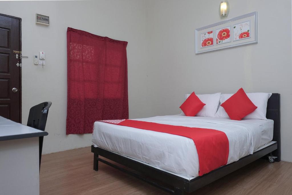 克提OYO 90080 Kay Inn Kerteh的一间卧室配有红色枕头的床
