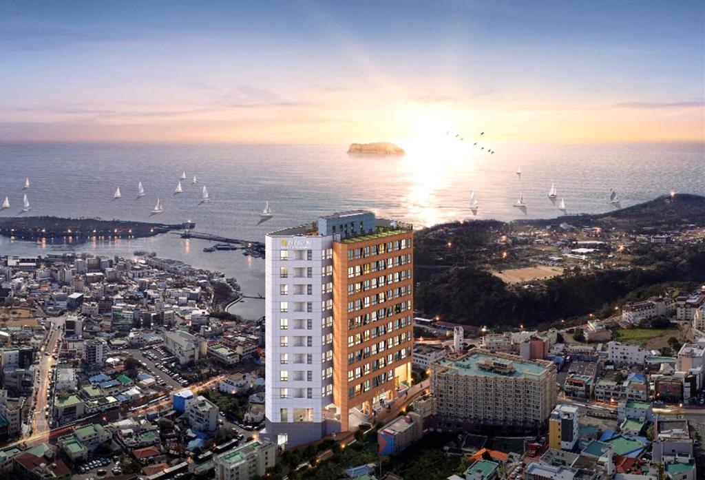 西归浦市Shin Shin Hotel Seogwipo的水面上帆船的城市景观