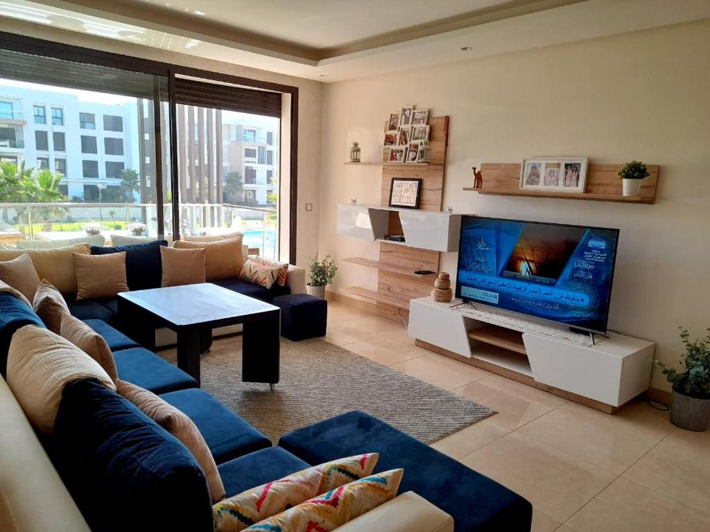 塞拉Vus sur mer et piscine的客厅配有蓝色的沙发和电视