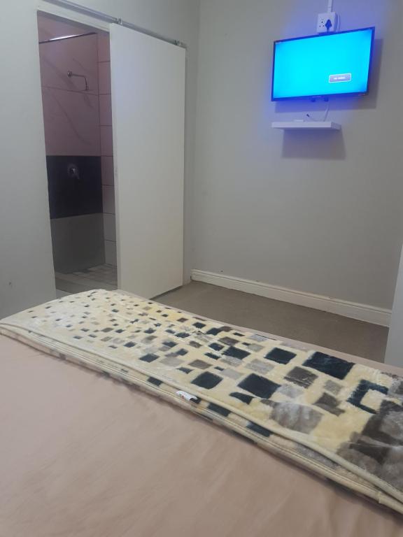 开普敦SALAMA LODGE的一间房间,电视机前设有一张棋盘床