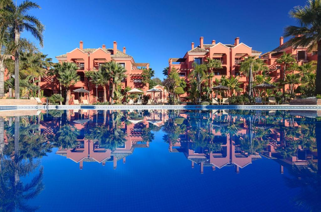 马贝拉瓦萨里度假酒店的棕榈树和别墅度假村的游泳池