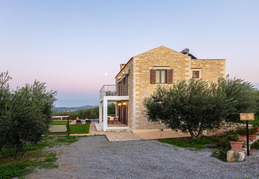AngelianaDimokritos Villas, a homestay experience, By ThinkVilla的带阳台和庭院的砖屋
