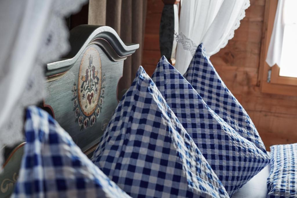 CuragliaNostalgie Bed & Breakfast Chrämerhus的一间设有蓝色和白色枕头的房间和窗户