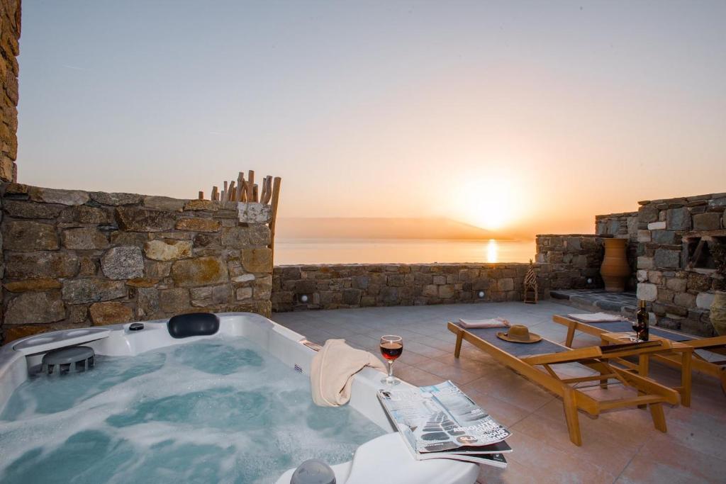 胡拉吉亚Gorgeous Studio In Cycladic Architecture Overlooking The Aegean的一个带桌子的客房内的按摩浴缸