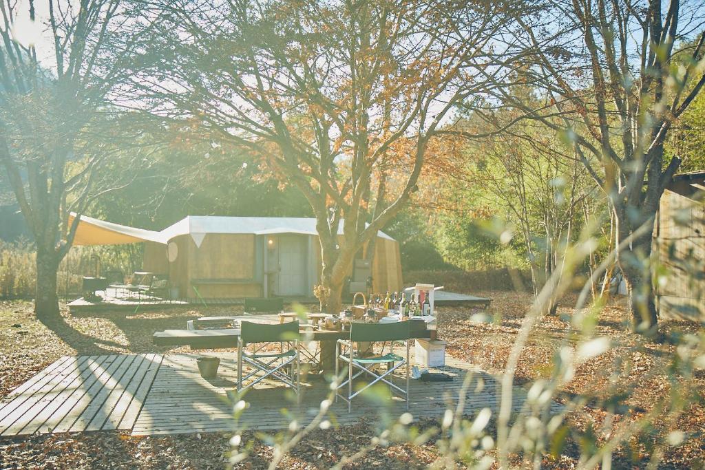 笛吹市LOOF Tiny House Camp的一个带棚子的院子内的野餐桌和椅子