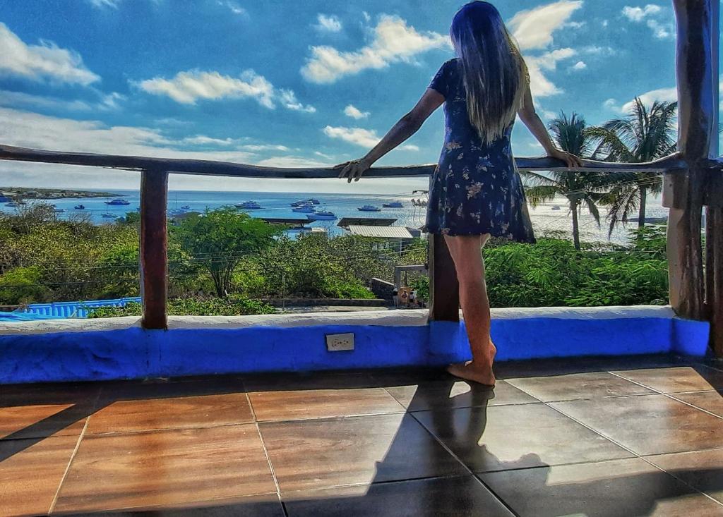 巴克里索莫雷诺港Galápagos Casa Playa Mann的站在一个眺望海洋的阳台上的女人