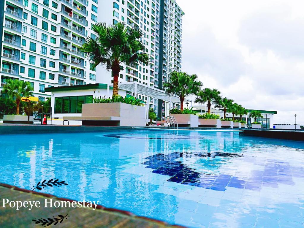 新山Luxury Premium Suite @ Kempas Johor Bahru的一座棕榈树和建筑的大型游泳池