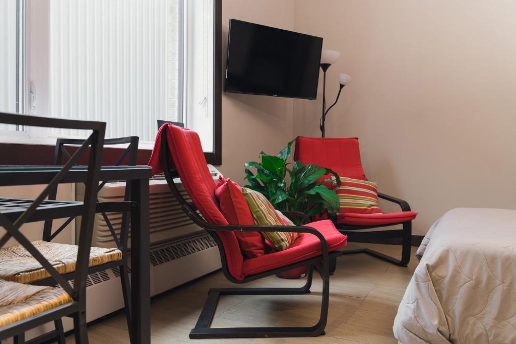 蒙特利尔科珠尔公寓的一间设有两把椅子、一张桌子和一台电视的房间