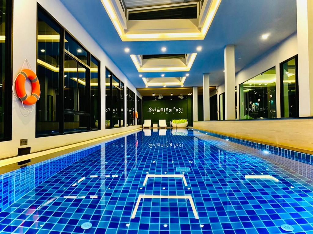 山甘烹The Vet Boutique Hotel - SHA Extra Plus的酒店内有一个蓝色瓷砖的游泳池