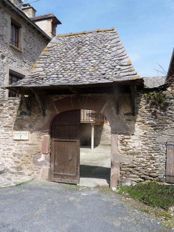 贝尔卡斯泰chambre d'hôtes Cadravals Belcastel Aveyron的石头建筑的入口,带有木门