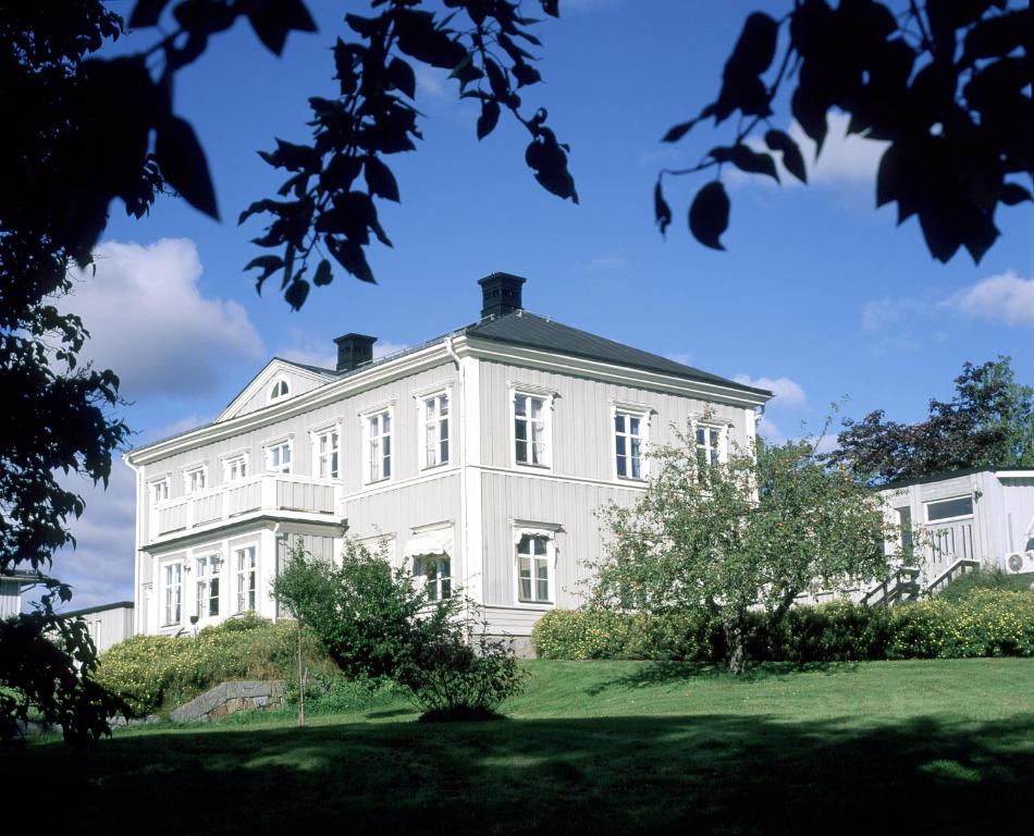 SöråkerSöråkers Timrå Herrgård的绿色草坪上的大型白色房屋