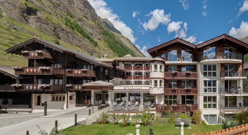 采尔马特SCHLOSS Zermatt - Active & CBD Spa Hotel的一座大建筑,背景是一座山