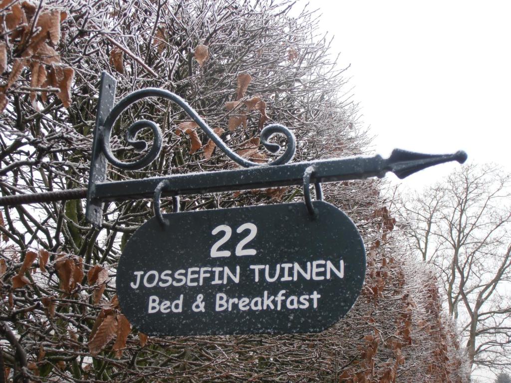 拉纳肯约瑟芬花园住宿加早餐旅馆的挂在雪地中的一根杆上的标志