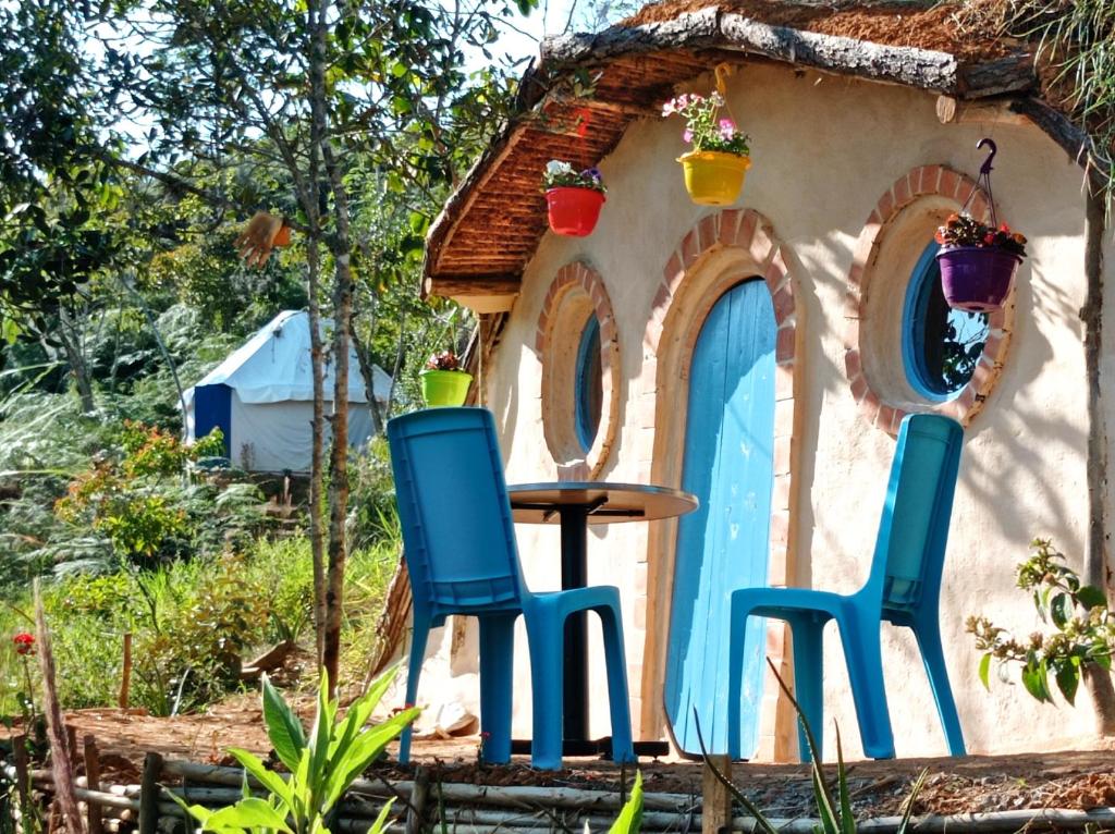 巴里查拉La Pacha Hostel的小房子前面的两把椅子和一张桌子