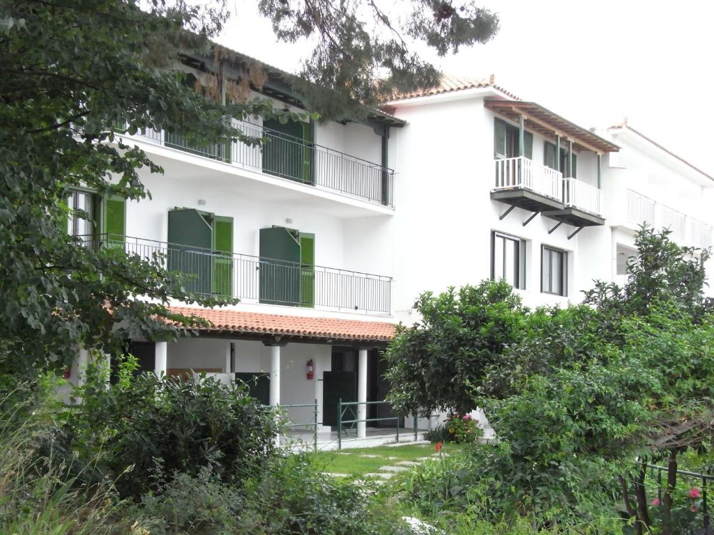 梅加利阿莫斯Villa Yiannis (Adult Friendly)的白色的建筑,拥有绿色的窗户和树木