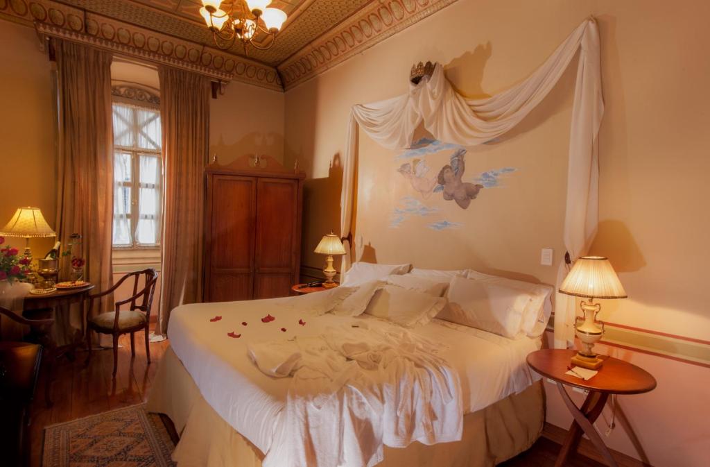 昆卡卡瓦洛酒店的一间卧室配有一张带天蓬的白色床