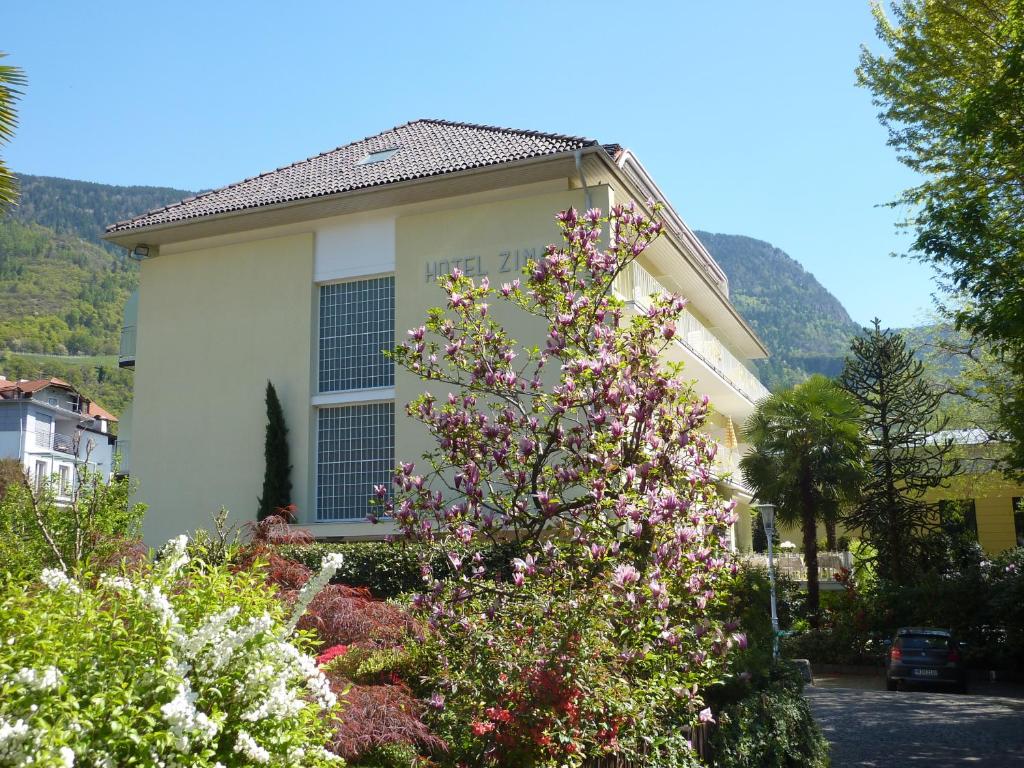 梅拉诺济马酒店的前面有一棵开花的树的房子