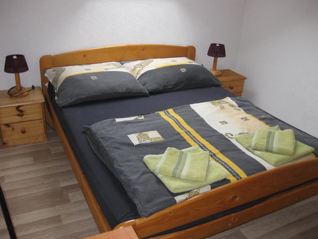 扎马迪Rent a Scooter Vendégház的一张带蓝色床单和绿色枕头的床