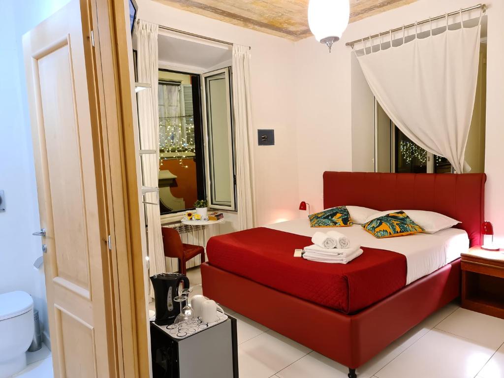 罗马我来借宿酒店的一间带红色床的卧室和一间浴室
