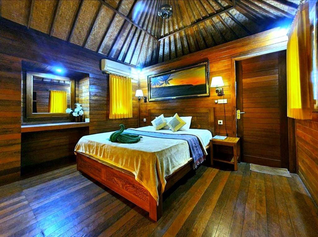 蓝梦岛Lembongan Tropical Guesthouse的木制客房内的一间卧室,配有一张床