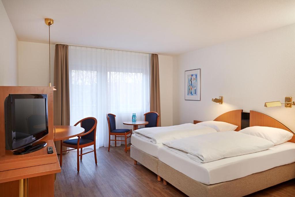 下恩豪森陶努斯山公寓酒店的酒店客房设有两张床和电视。