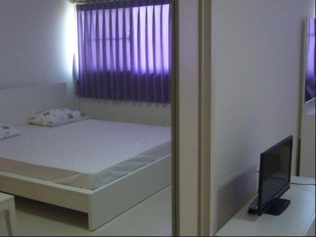 暖武里府Room in BB - Dmk Don Mueang Airport Guest House的窗户客房内的小床